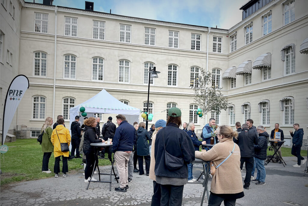 Bilden visar människor som minglar vid ståbord.